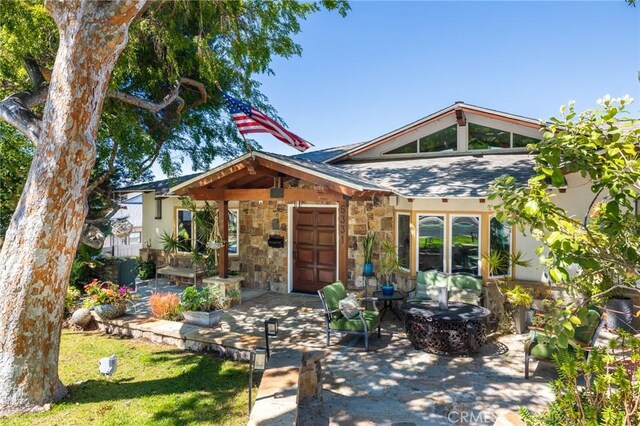 view of front of home featuring a patio and stone siding