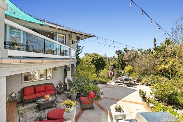 view of yard featuring a patio, outdoor lounge area, and a balcony