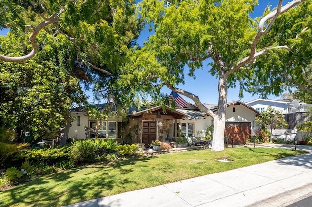 ranch-style house with driveway, a garage, a front lawn, stone siding, and stucco siding