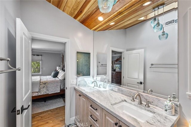 ensuite bathroom with ensuite bathroom, a sink, and lofted ceiling