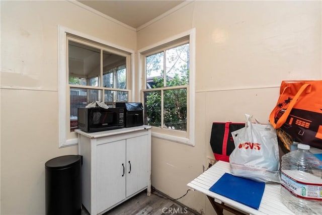 interior space with wood finished floors and crown molding