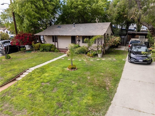 single story home with a shingled roof and a front lawn