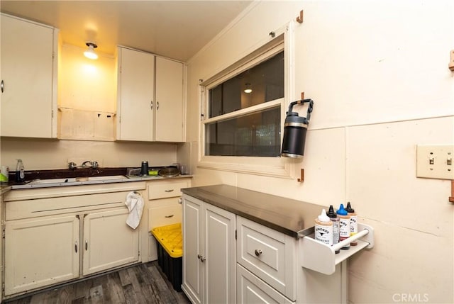 kitchen with dark countertops, a sink, and dark wood finished floors