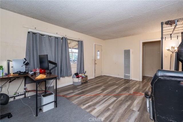 office area featuring wood finished floors, a textured ceiling, and a heating unit