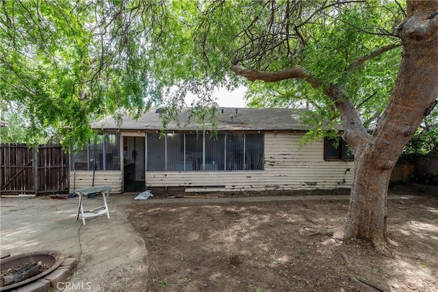 back of property featuring a patio area, a sunroom, and fence
