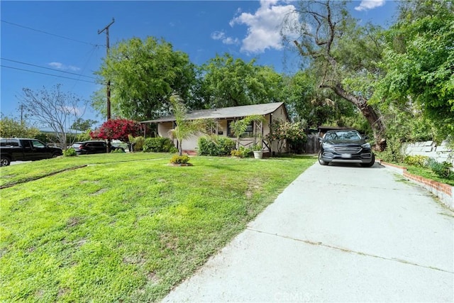single story home featuring a front lawn and concrete driveway