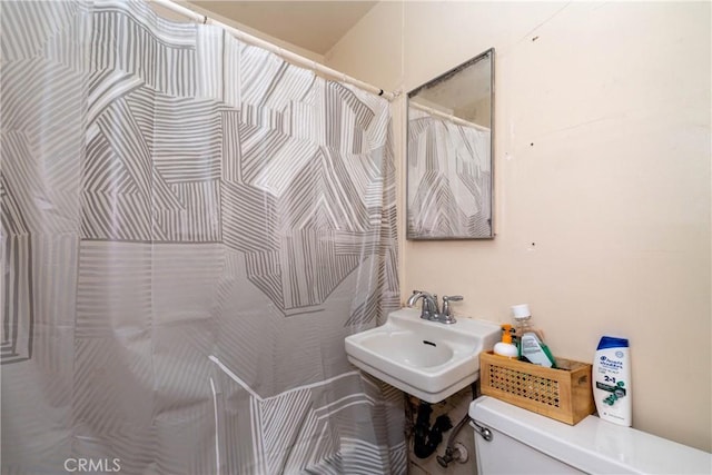 full bath with curtained shower, a sink, and toilet