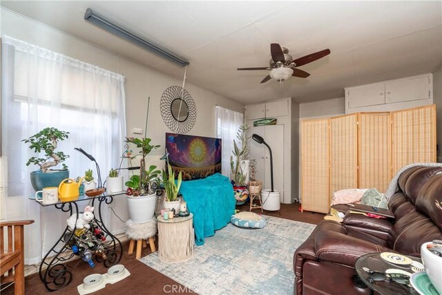 living area featuring carpet floors and ceiling fan