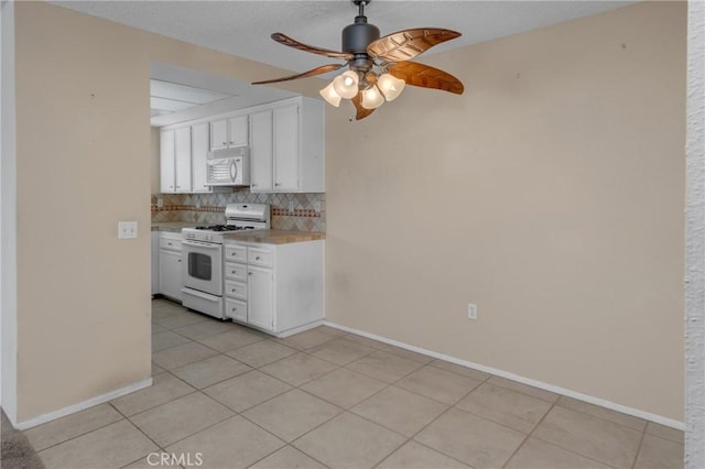 kitchen featuring light countertops, white appliances, ceiling fan, white cabinetry, and backsplash