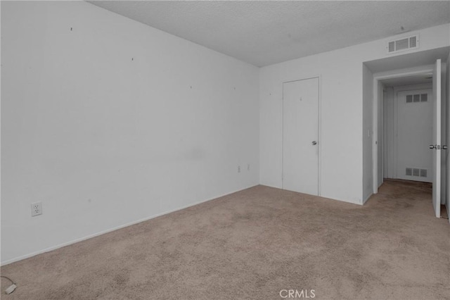 interior space with visible vents, carpet floors, and a textured ceiling