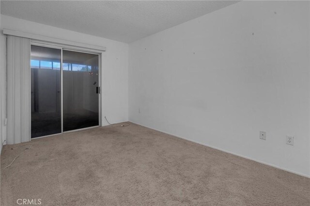 carpeted spare room featuring a textured ceiling