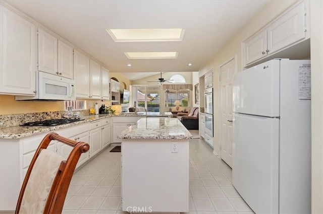 40636 Via Jalapa, Murrieta, CA 92562 - kitchen featuring open floor plan, white cabinetry, a kitchen island, and white appliances
