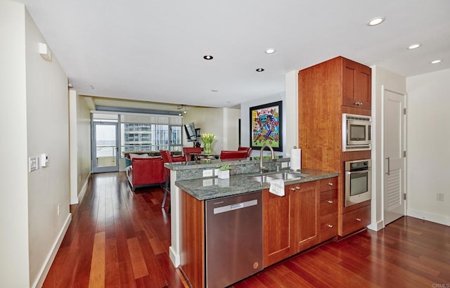 700 W E St Unit 2802, San Diego, CA 92101 - kitchen featuring appliances with stainless steel finishes, a sink, dark wood finished floors, open floor plan, and recessed lighting
