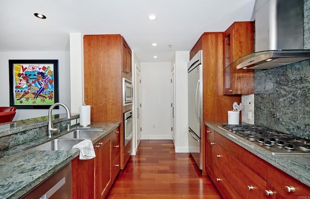 700 W E St Unit 2802, San Diego, CA 92101 - kitchen featuring wall chimney exhaust hood, built in appliances, a sink, dark wood finished floors, and light stone countertops