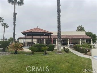 view of front of home with a tile roof, a gazebo, and a front yard