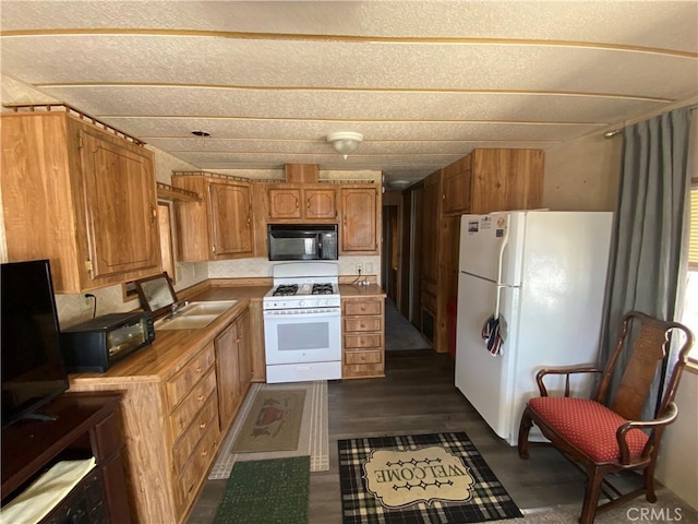kitchen with a sink, brown cabinetry, dark wood-style flooring, white appliances, and light countertops