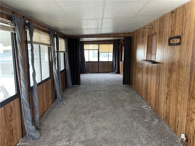 hall featuring carpet flooring and wood walls