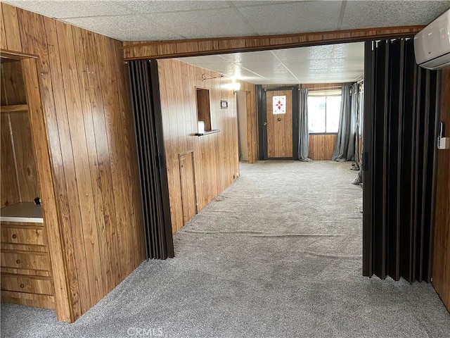corridor with a wall mounted AC, wooden walls, and carpet floors