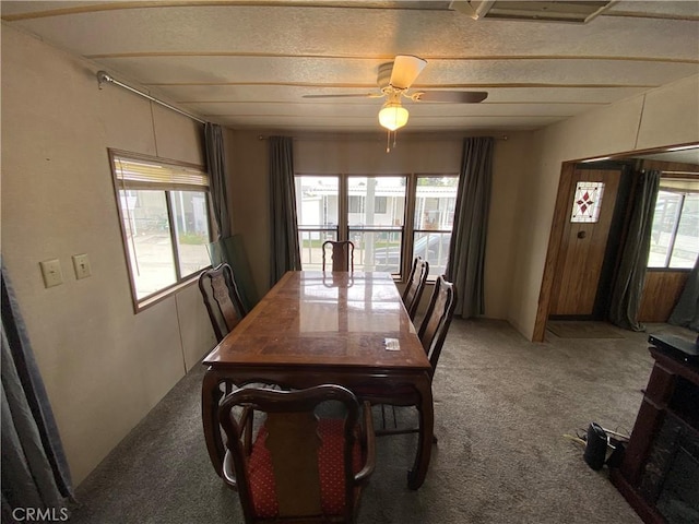 dining area featuring light colored carpet, a ceiling fan, and a healthy amount of sunlight