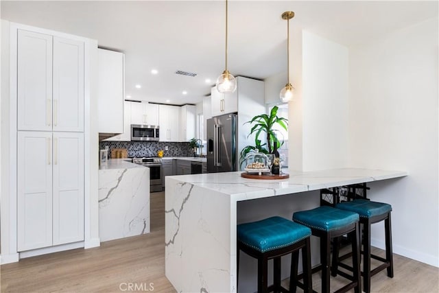9038 Whitaker Ave, Northridge, CA 91343 - kitchen featuring appliances with stainless steel finishes, a peninsula, light wood-style flooring, light stone counters, and recessed lighting