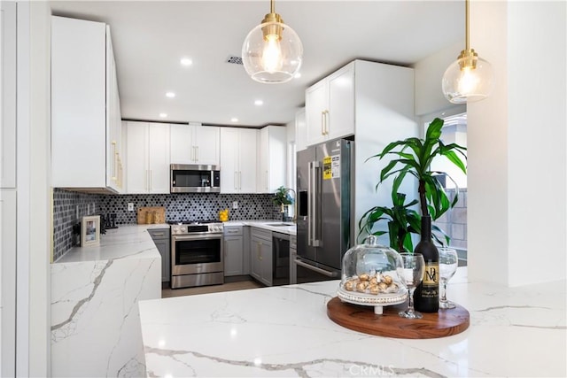 9038 Whitaker Ave, Northridge, CA 91343 - kitchen with stainless steel appliances, decorative backsplash, light stone countertops, white cabinets, and recessed lighting