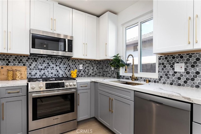9038 Whitaker Ave, Northridge, CA 91343 - kitchen with appliances with stainless steel finishes, gray cabinetry, tasteful backsplash, and light stone countertops