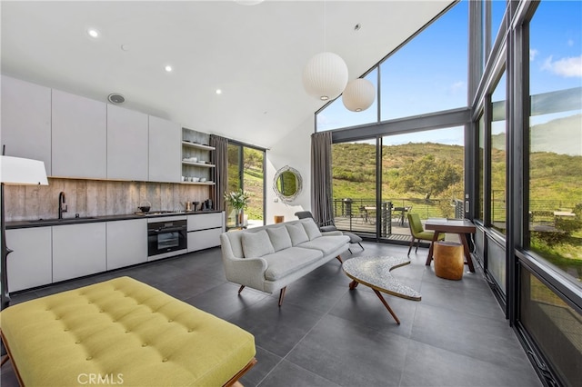 living area featuring high vaulted ceiling and recessed lighting