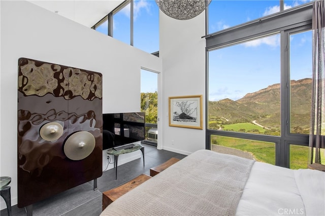 bedroom featuring baseboards, a high ceiling, and a mountain view
