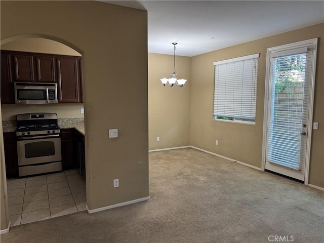 13312 Frederick Way, Sylmar, CA 91342 - kitchen with appliances with stainless steel finishes, light colored carpet, a chandelier, and dark brown cabinetry