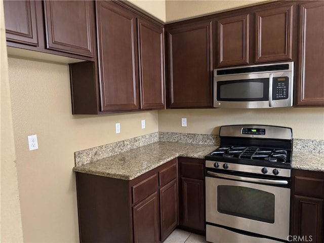 13312 Frederick Way, Sylmar, CA 91342 - kitchen featuring appliances with stainless steel finishes, dark brown cabinets, and light stone countertops