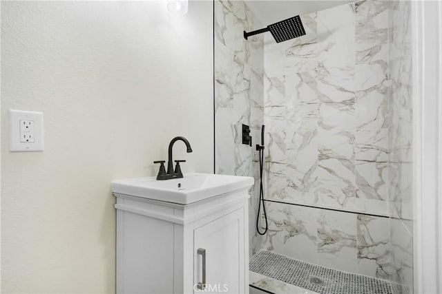 bathroom featuring vanity and a marble finish shower