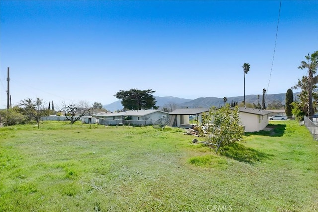 view of yard featuring a mountain view and fence