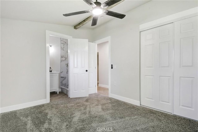 unfurnished bedroom featuring carpet floors, baseboards, a closet, and ensuite bathroom