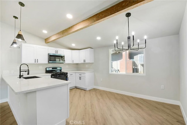 kitchen with range with gas cooktop, a sink, light wood-type flooring, stainless steel microwave, and vaulted ceiling with beams