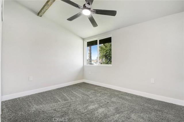 spare room featuring dark carpet, baseboards, ceiling fan, and vaulted ceiling