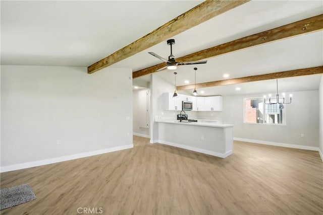 unfurnished living room featuring recessed lighting, light wood-type flooring, baseboards, and ceiling fan with notable chandelier