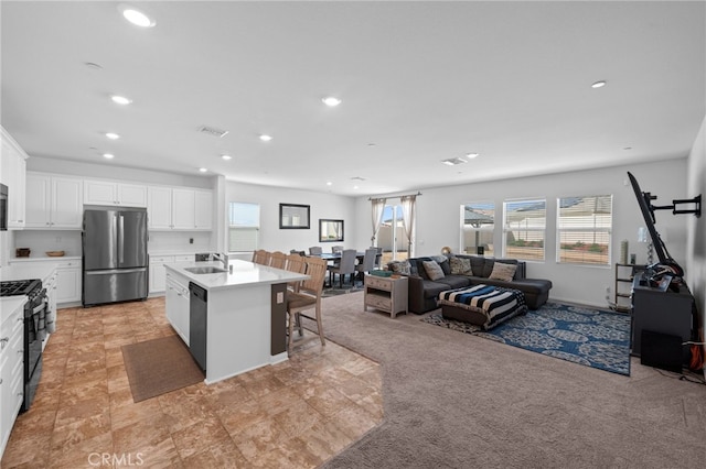 kitchen featuring a sink, visible vents, black appliances, and open floor plan