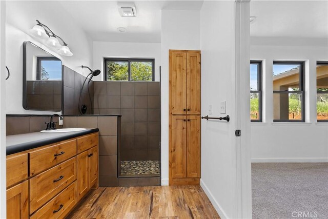 6010 Sunny Ln, Paradise, CA 95969 - full bathroom with tiled shower, plenty of natural light, vanity, and wood finished floors