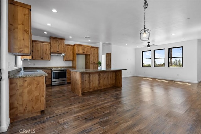 6010 Sunny Ln, Paradise, CA 95969 - kitchen with stainless steel range with electric cooktop, a sink, brown cabinets, under cabinet range hood, and a ceiling fan