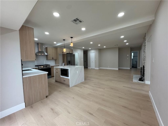 4609 Highgrove Ave, Torrance, CA 90505 - kitchen with wall chimney range hood, gas stove, black fridge with ice dispenser, a center island, and baseboards