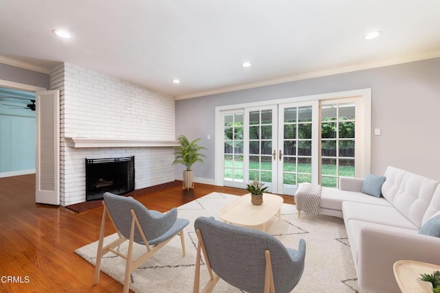 4402 El Camino Corto Ln, Canada Flintridge, CA 91011 - living area with ornamental molding, french doors, wood finished floors, a brick fireplace, and recessed lighting