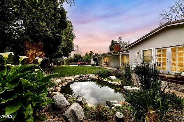 4402 El Camino Corto Ln, Canada Flintridge, CA 91011 - yard at dusk featuring a yard, a patio, french doors, and a small pond
