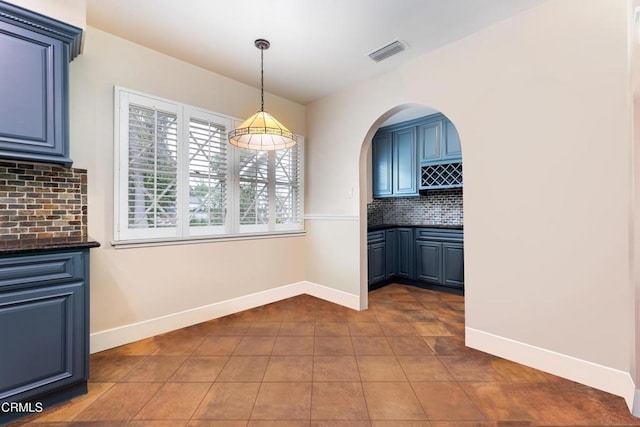 4402 El Camino Corto Ln, Canada Flintridge, CA 91011 - unfurnished dining area featuring baseboards, dark tile patterned flooring, and arched walkways