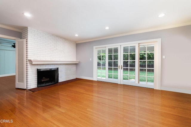 4402 El Camino Corto Ln, Canada Flintridge, CA 91011 - unfurnished living room featuring a brick fireplace, crown molding, wood finished floors, recessed lighting, and french doors