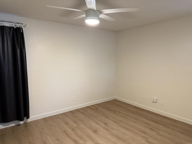 empty room with a ceiling fan, baseboards, and light wood finished floors