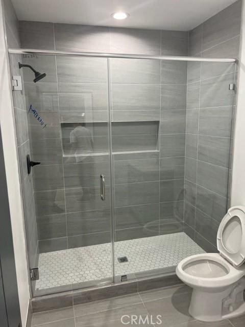 6927 Lindley Ave, Reseda, CA 91335 - bathroom featuring tile patterned flooring, toilet, a stall shower, and recessed lighting