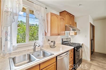 6927 Lindley Ave, Reseda, CA 91335 - kitchen featuring under cabinet range hood, range with gas cooktop, stainless steel dishwasher, a sink, and light countertops