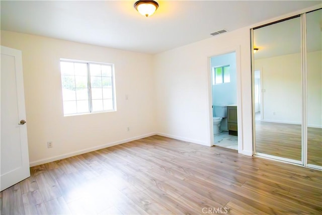 6927 Lindley Ave, Reseda, CA 91335 - unfurnished bedroom with multiple windows, light wood-style flooring, and baseboards