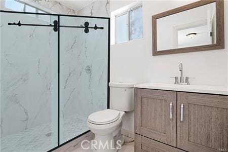 6927 Lindley Ave, Reseda, CA 91335 - bathroom featuring toilet, vanity, a marble finish shower, and plenty of natural light