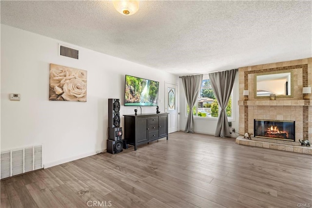 6927 Lindley Ave, Reseda, CA 91335 - unfurnished living room featuring a textured ceiling, a large fireplace, wood finished floors, and baseboards